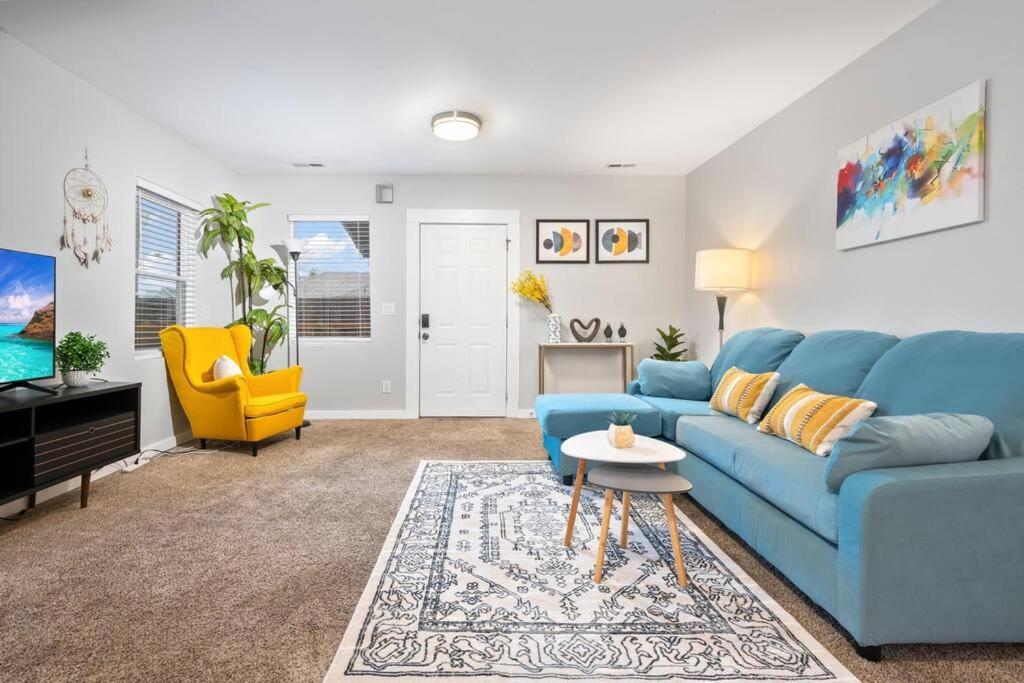 a living room with a blue couch and a yellow chair at Cozy and 3 mins to Tacoma dome. in Tacoma