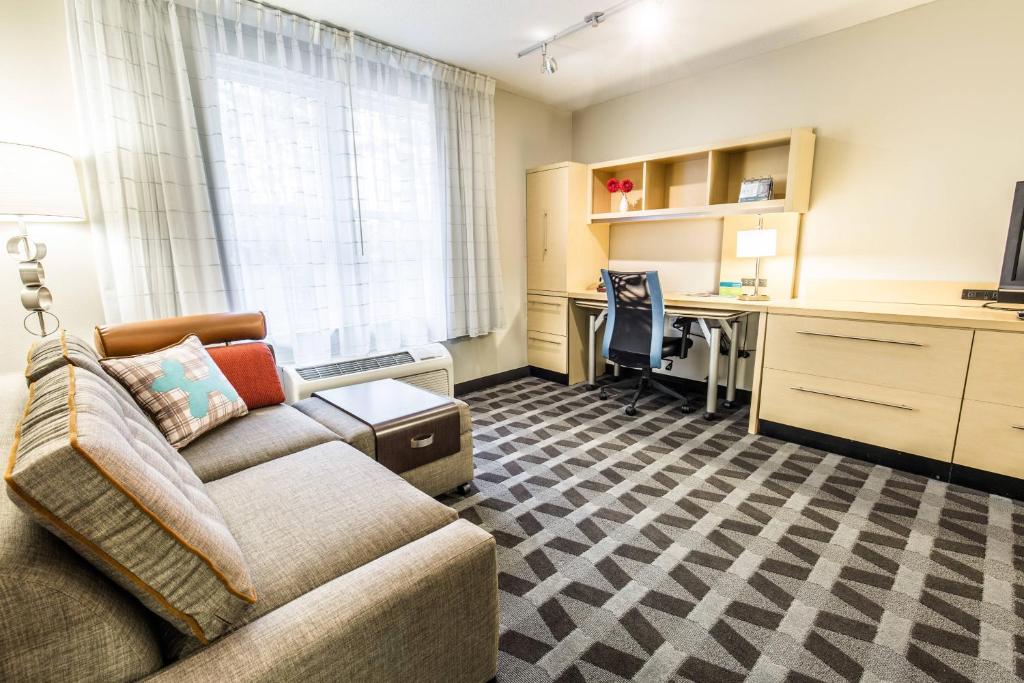a living room with a couch and a desk at TownePlace Suites by Marriott Gilford in Gilford
