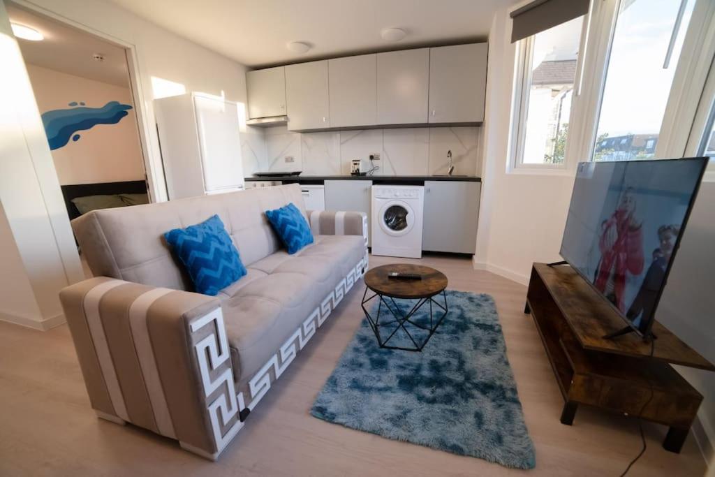 een woonkamer met een bank en een tafel bij Spacious and Stylish 1 Bed Modern Flat in Londen