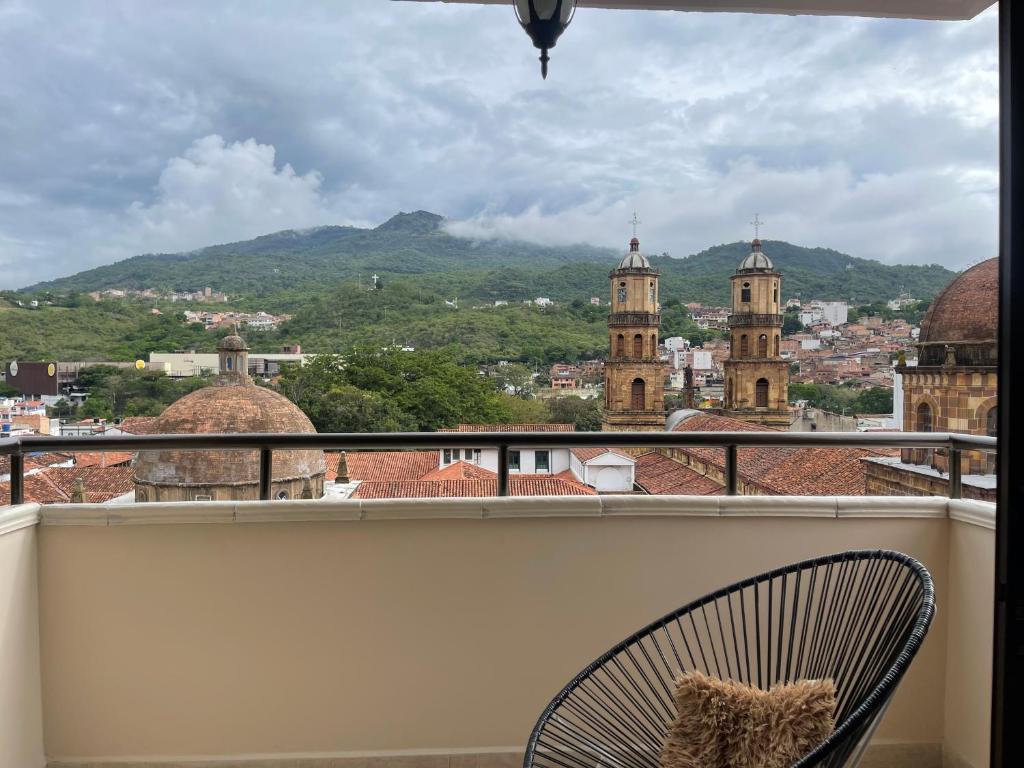 a chair on a balcony with a view of a city at APARTAMENTO EN EL CENTRO HISTÓRICO in San Gil