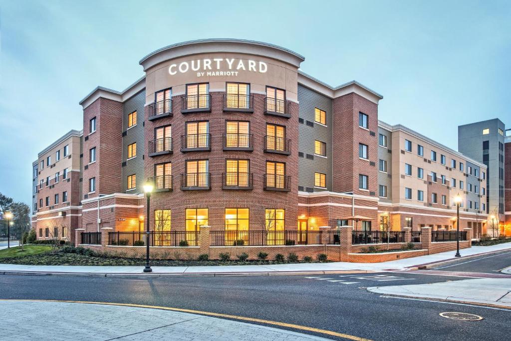 un grand bâtiment en briques avec une pharmacie près de la cour dans l'établissement Courtyard by Marriott Glassboro Rowan University, à Glassboro