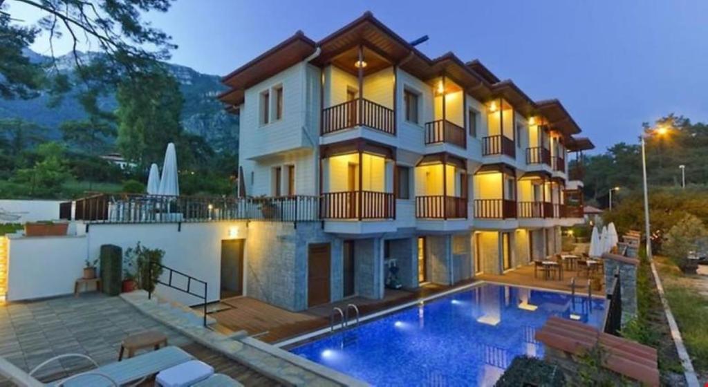 a hotel with a swimming pool in front of a building at SUMMER OTEL in Mugla