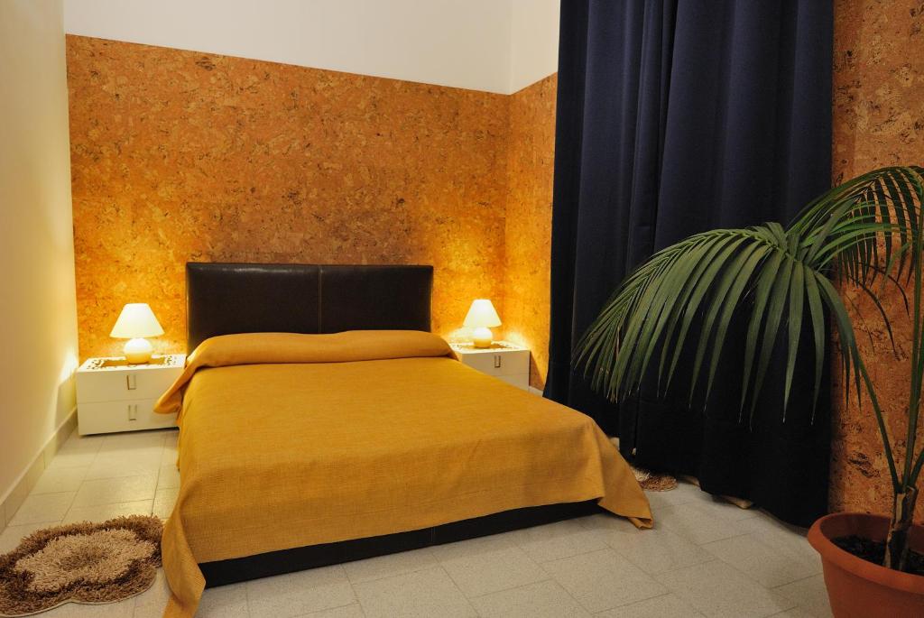 レッチェにあるAppartamento B&B Ariostoのベッドルーム(ベッド1台、鉢植えの植物付)