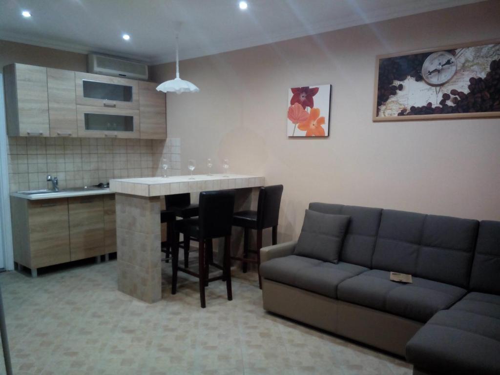 a kitchen and living room with a couch and a table at Manó Apartman in Eger