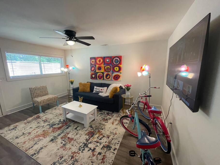 a living room with a couch and a tv at Modern ~ Comfortable ~ Downtown, Queen beds, Bikes in Greenville