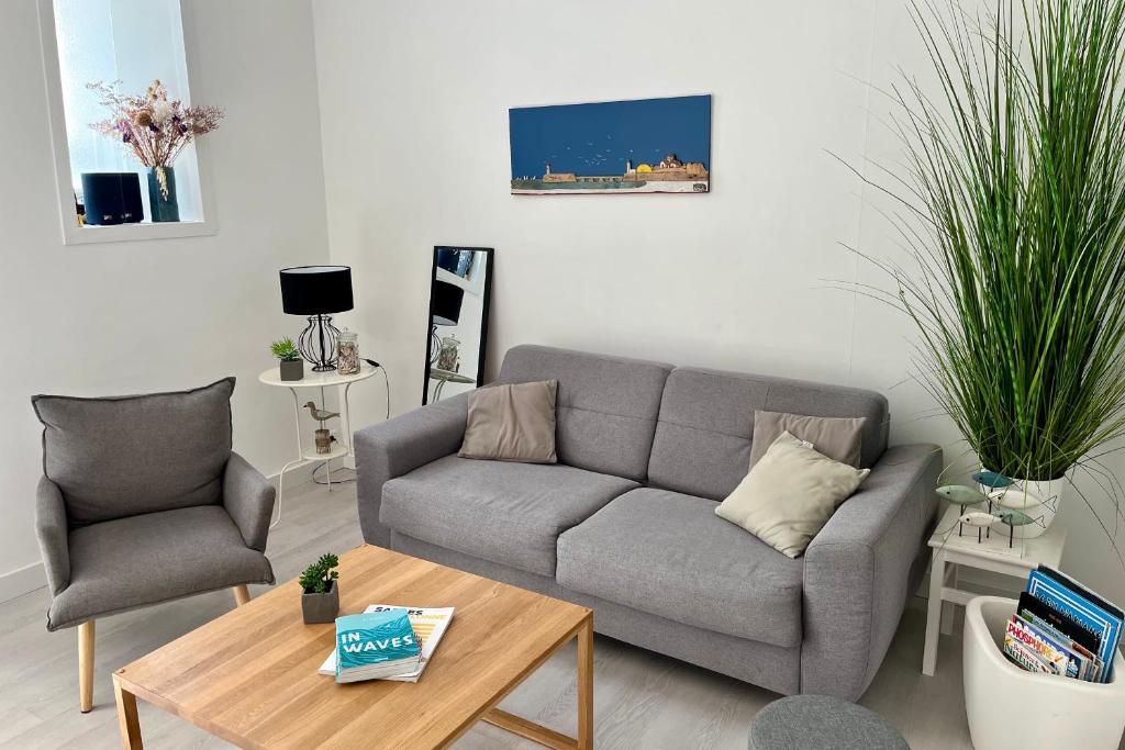 un salon avec un canapé et une table dans l'établissement Bel appartement à 50m de la Grande Plage, à Les Sables-dʼOlonne