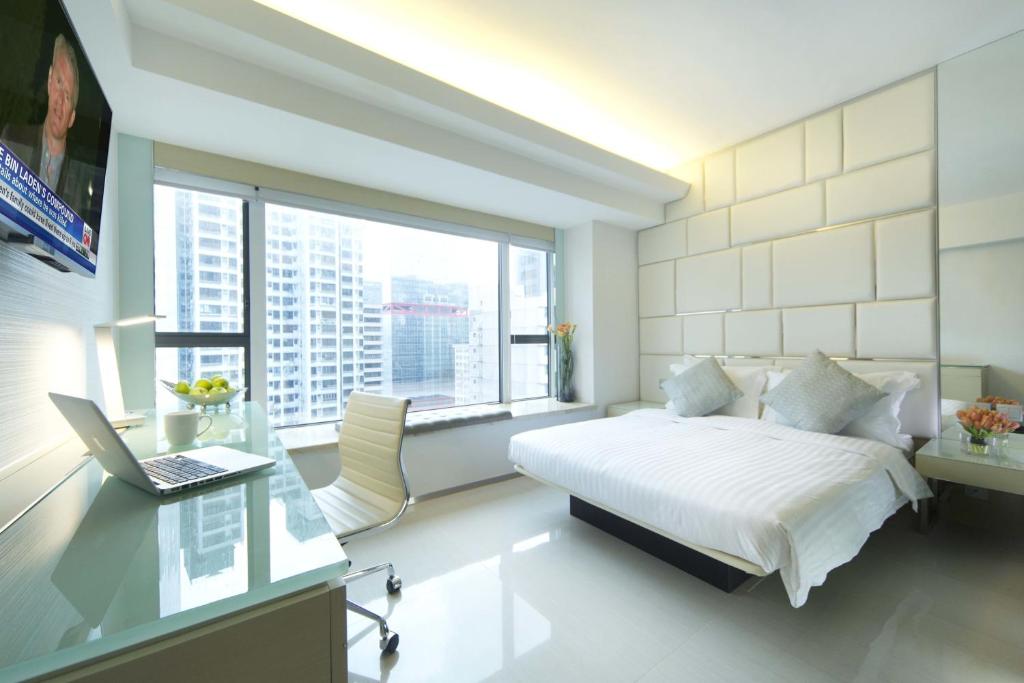 فندق ايكلوب شيونغ وان  في هونغ كونغ: غرفة نوم مع سرير ومكتب مع الكمبيوتر المحمول