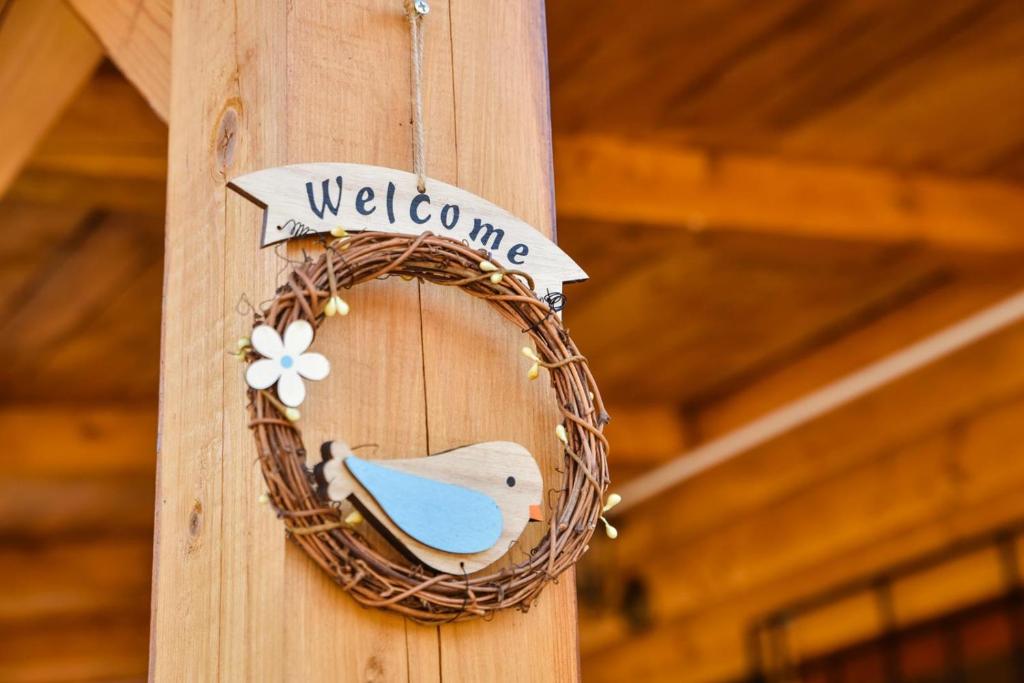 a wreath on a wooden post with a welcome sign at Chalet Mediterraneo in Ulcinj