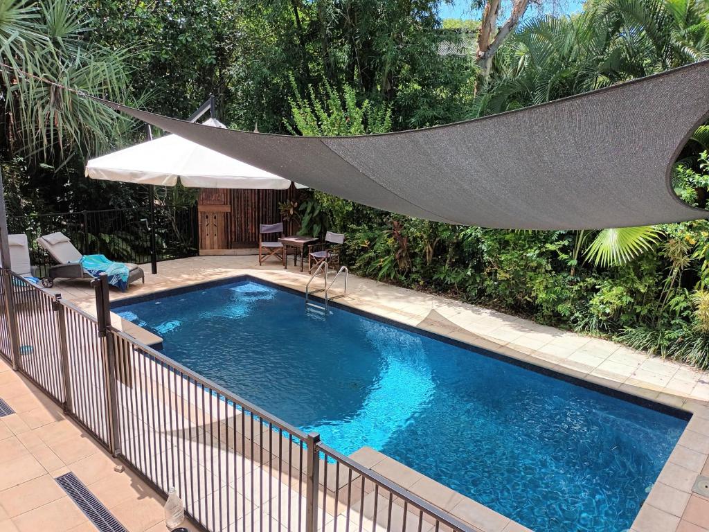 a large swimming pool with a hammock over it at Tropical Poolside Retreat in Nelly Bay