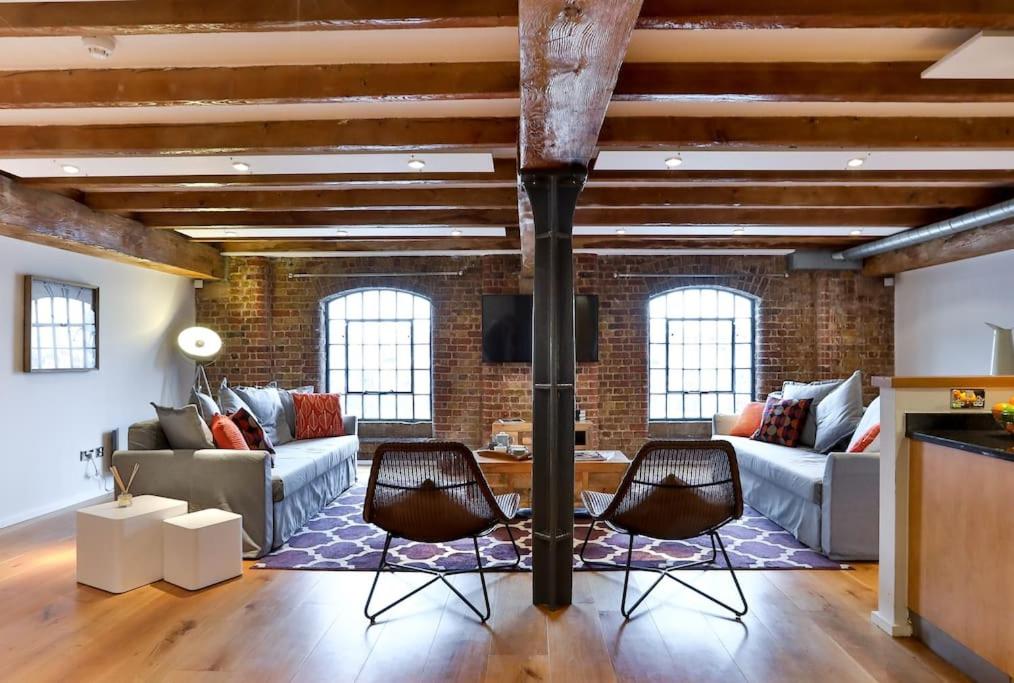 a living room with a brick wall at Wild Roses Serviced Apartments - ExCel Warehouse 1 in London