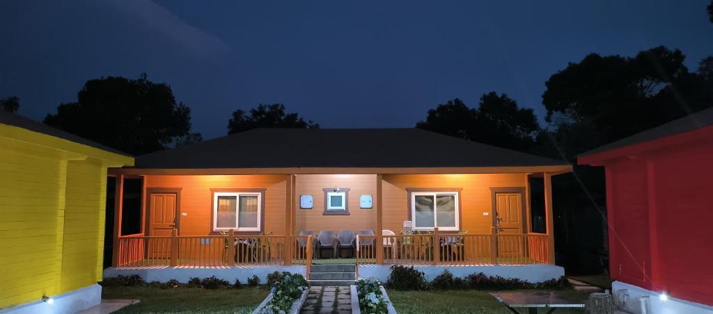 a small house with a deck at night at The Laughing Woods AC Resort in Kotagiri
