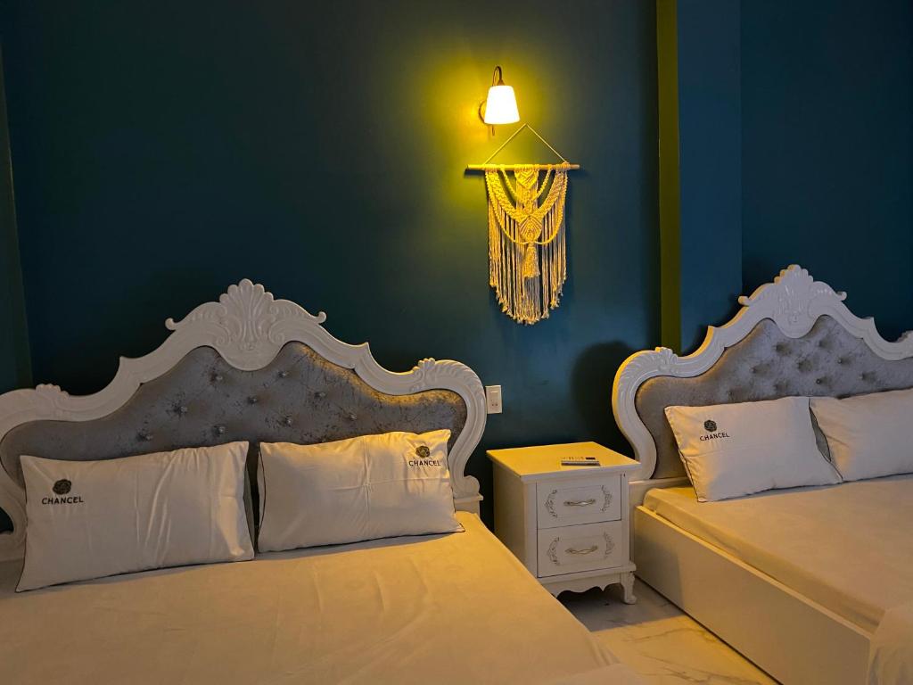 1 dormitorio con 2 camas y pared azul en Cat Ba Santorini Homestay, en Cat Ba