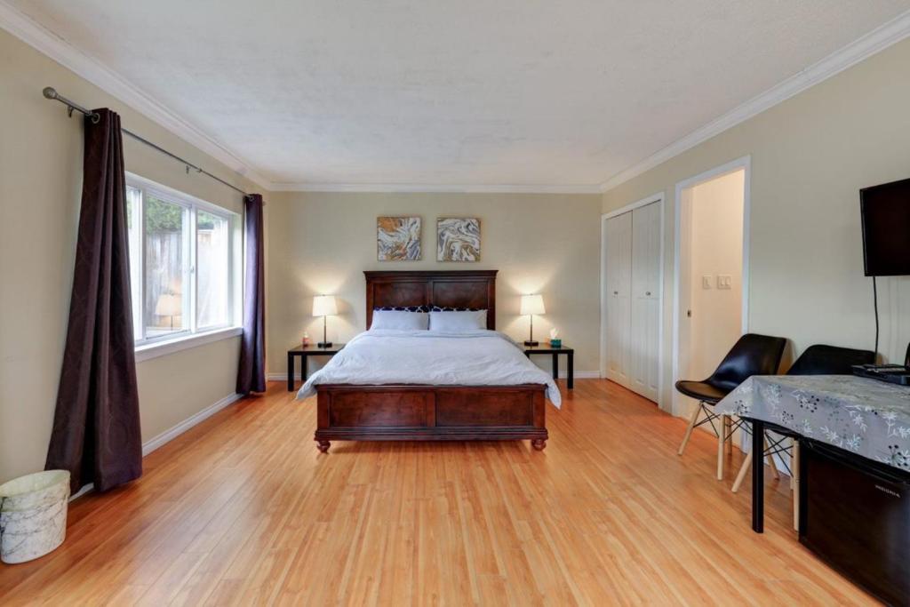 1 dormitorio con 1 cama y suelo de madera en Private Suite with Separated Entrance Monica's Home, en Richmond