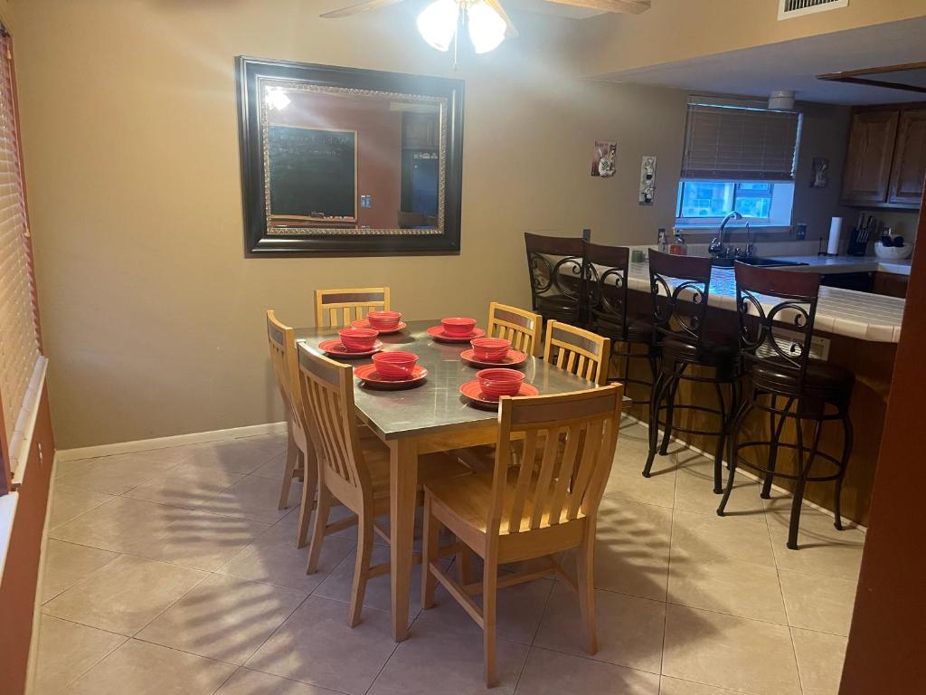a dining room with a table with red dishes on it at Private Oasis Condo with River views across from Laughlin in Bullhead City