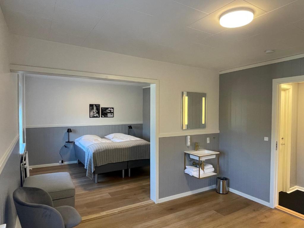 a bedroom with a bed and a chair in a room at Annex in Frederikshavn