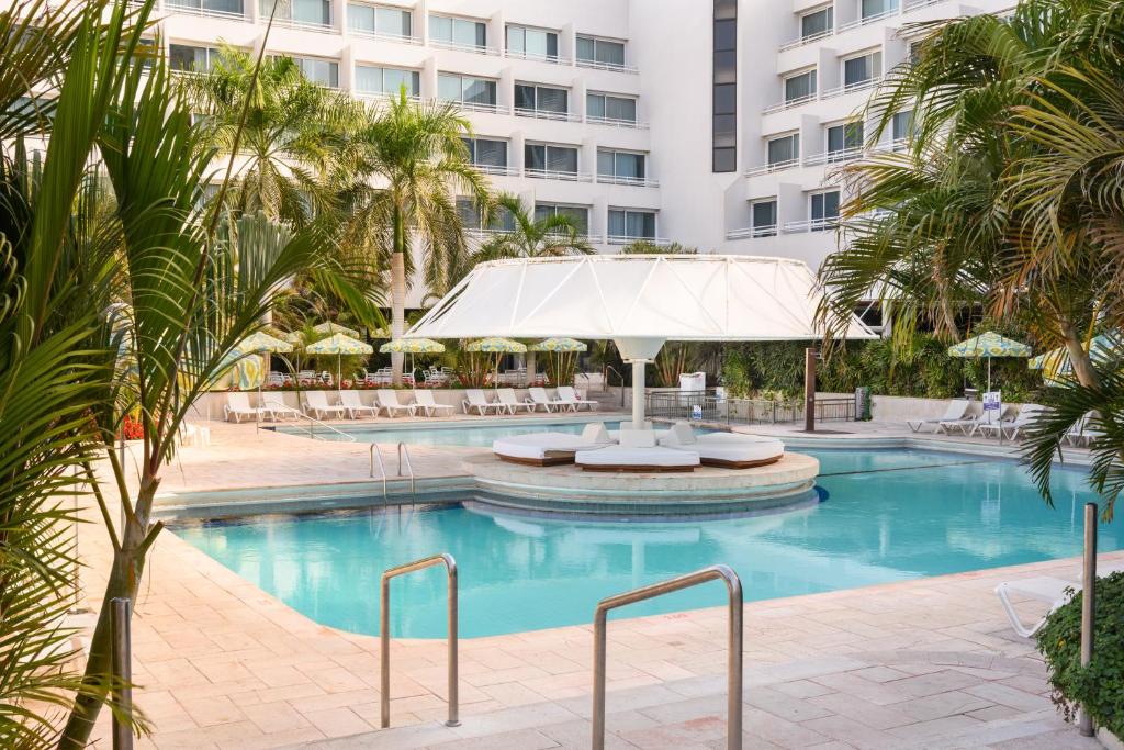 a swimming pool with a large building in the background at Lagoona by Isrotel Collection in Eilat