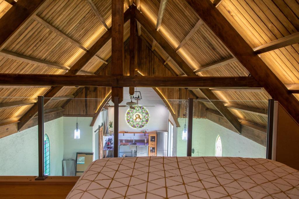 um quarto amplo com tectos em madeira e uma cama grande em The Church Millers Flat em Millers Flat
