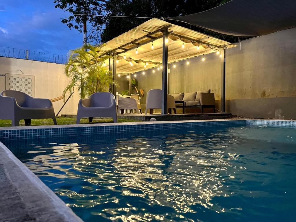 a swimming pool with a tent and a table and chairs at La Coqueta in Herradura