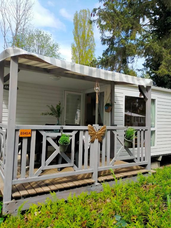 a tiny house with a porch and a deck at Mobilhome in Boofzheim