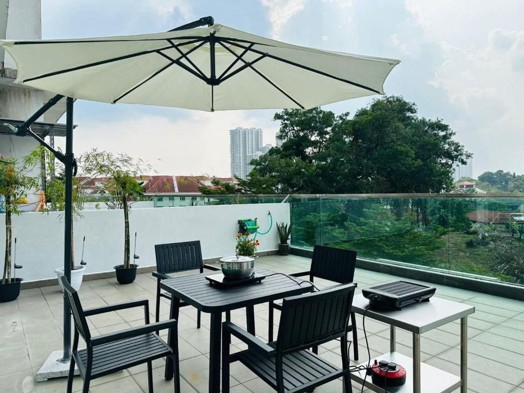 um pátio com uma mesa, cadeiras e um guarda-sol em Paragon Residence 8-12pax-Big Balcony with BBQ em Johor Bahru