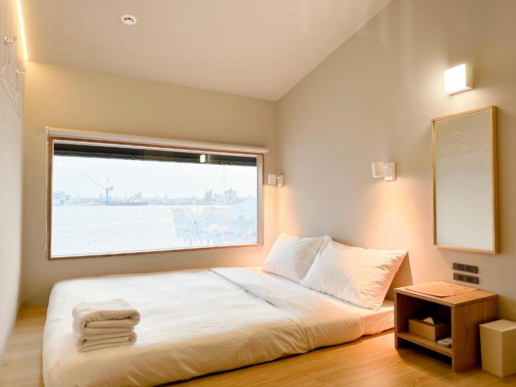 una camera da letto con un letto grande con una finestra di KW2 Hostel a Kaohsiung