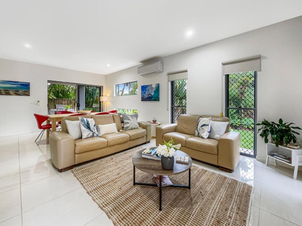 a living room with two couches and a table at Casa Mia Retreat Luxury Family Home on Buderim in Buderim