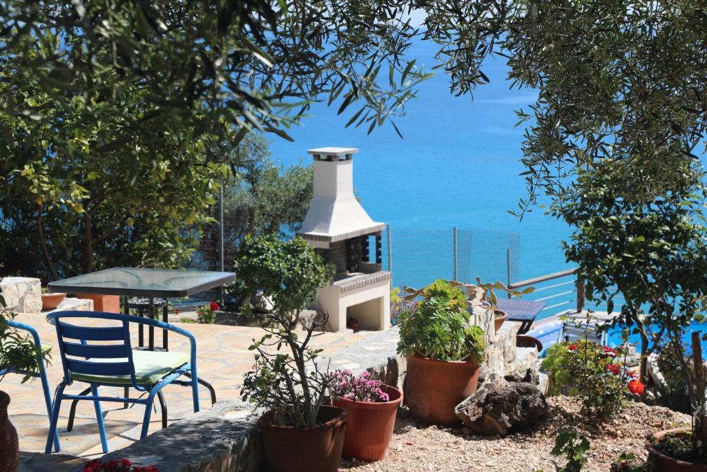 a patio with a fireplace with chairs and plants at Zante Xigia Bay villas in Khartáta