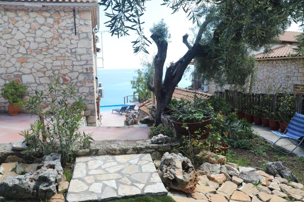 a garden with a tree and a stone walkway at Zante Xigia Bay villas in Khartáta