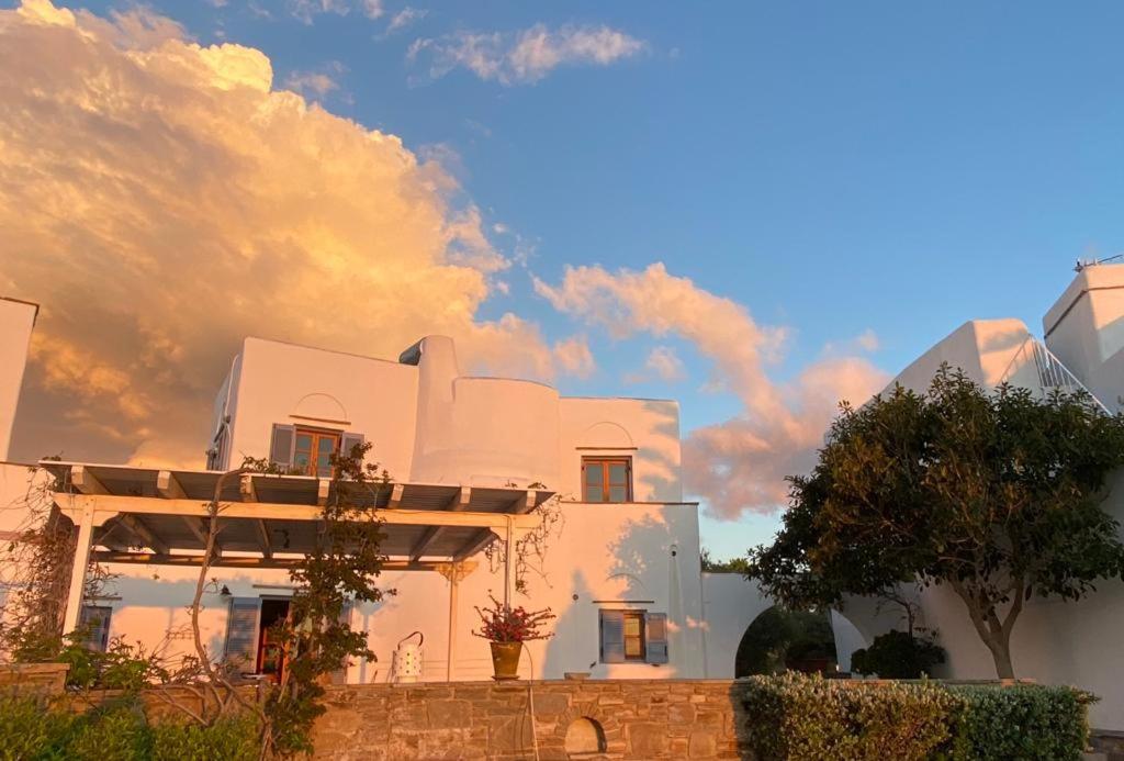 a white building with a cloudy sky in the background at Plaka Villa 2 Naxos in Plaka
