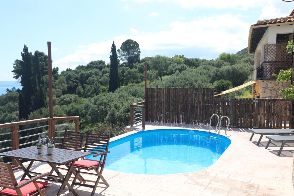 a swimming pool with chairs and a table and a house at Zante Xigia Bay villas in Khartáta