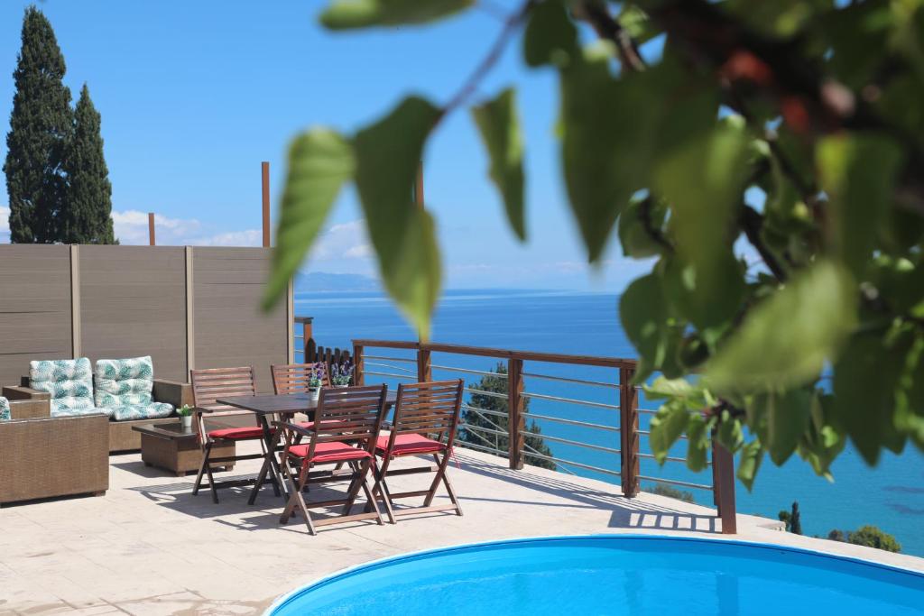 a patio with a table and chairs and the ocean at Zante Xigia Bay villas in Khartáta