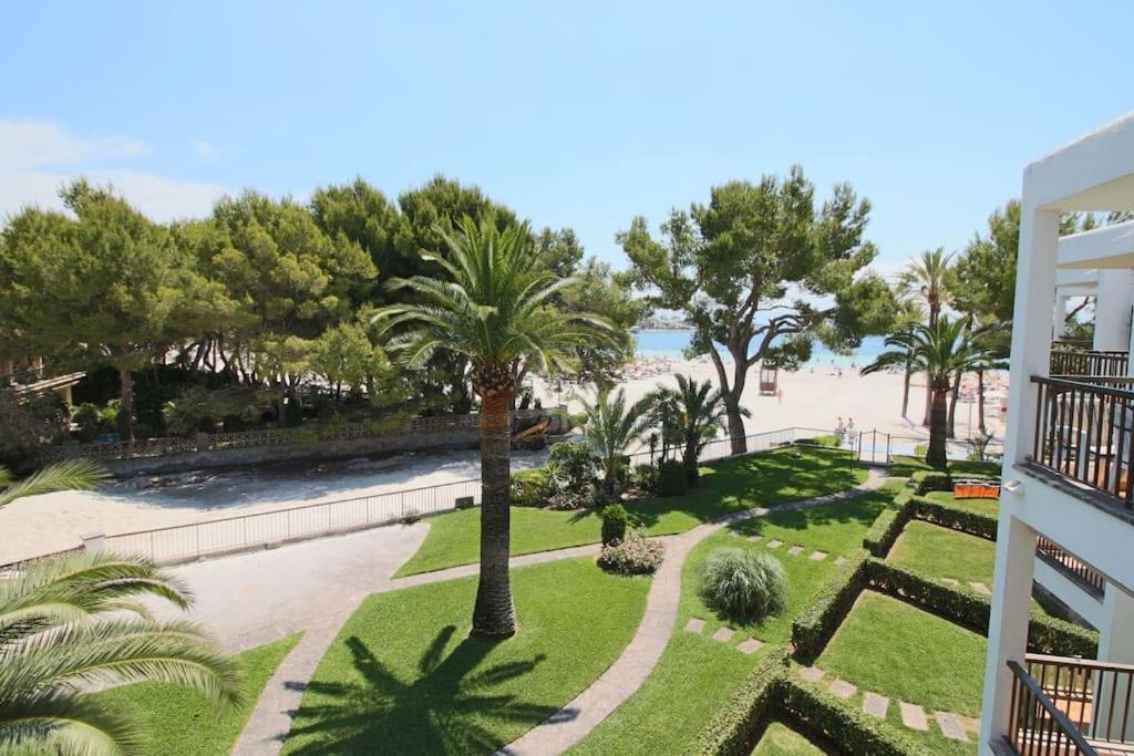 a view of a park with palm trees and the beach at Elena Playa Sol in Alcudia