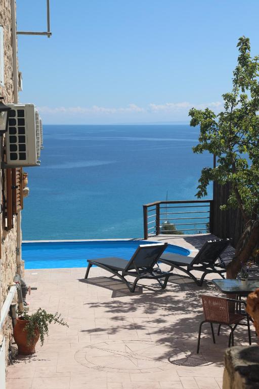 a patio with chairs and a view of the ocean at Zante Xigia Bay villas in Khartáta