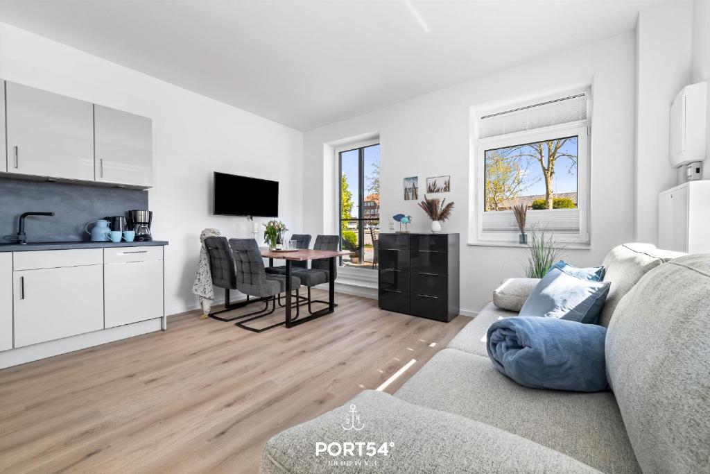 a kitchen and living room with a couch and a table at Strandperle Gelting in Gelting