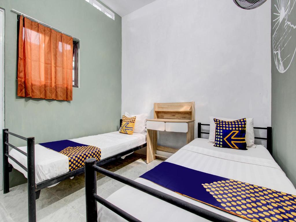 um quarto com três camas e uma janela em SPOT ON 92490 Casa Homestay Syariah em Brangsong