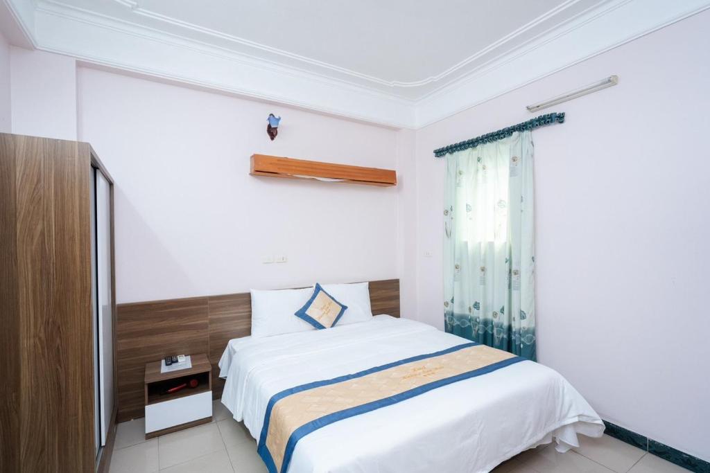 a white bedroom with a bed and a window at Hoàng Sơn Hải Hotel in Lạng Sơn