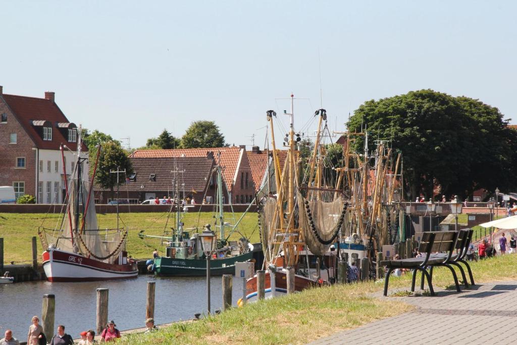um grupo de barcos ancorados numa massa de água em Bummert Am Hafen 1 em Krummhörn