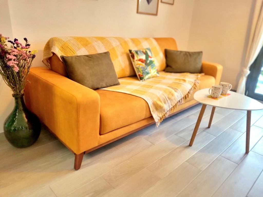 - un canapé orange dans le salon avec une table dans l'établissement Tiffany's apartments -2' walk from Metro, à Athènes