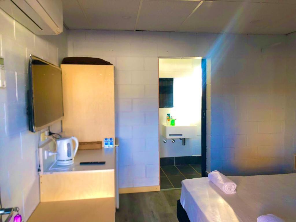 坎納馬拉的住宿－OXFORD HOTEL MOTEL，小房间设有一张床和一间浴室