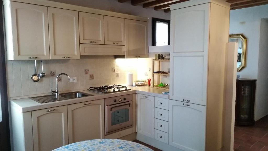 a kitchen with white cabinets and a sink at Mare Colline Relax in Montignoso