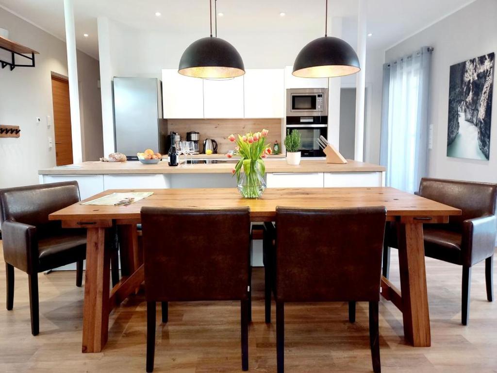 a dining room table with chairs and a vase of flowers at Ferienhaus K4 in Garmisch-Partenkirchen in Garmisch-Partenkirchen