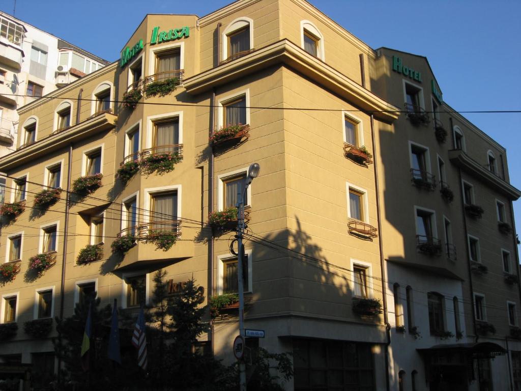 um edifício alto com plantas ao lado dele em Hotel Irisa em Bucareste
