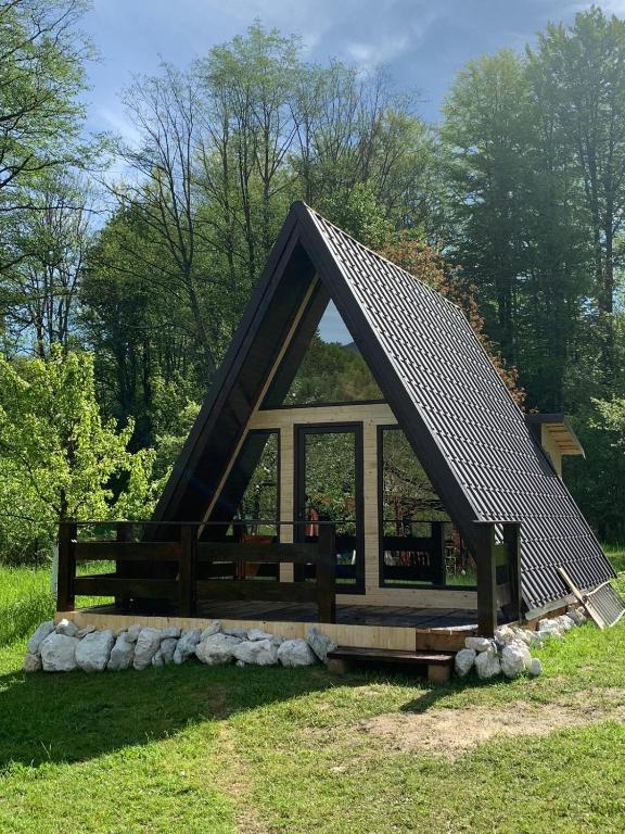 a small house with a pointed roof in a field at Casa de vacanța Cristina in Cîmpu lui Neag