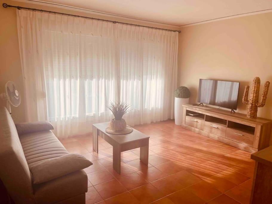 a living room with a couch and a tv at Apartamento en primera línea de playa in Denia