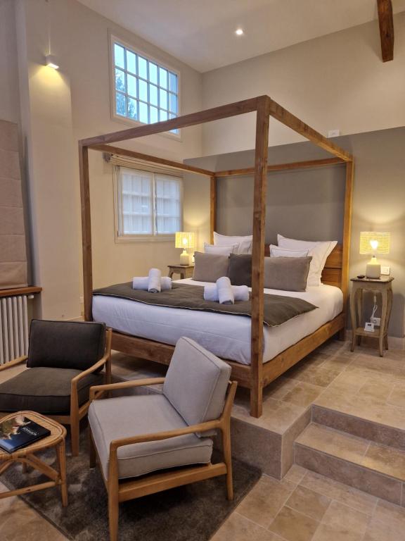 een slaapkamer met een groot bed en een stoel bij Au Moulin Saint Nicol - Honfleur in Honfleur