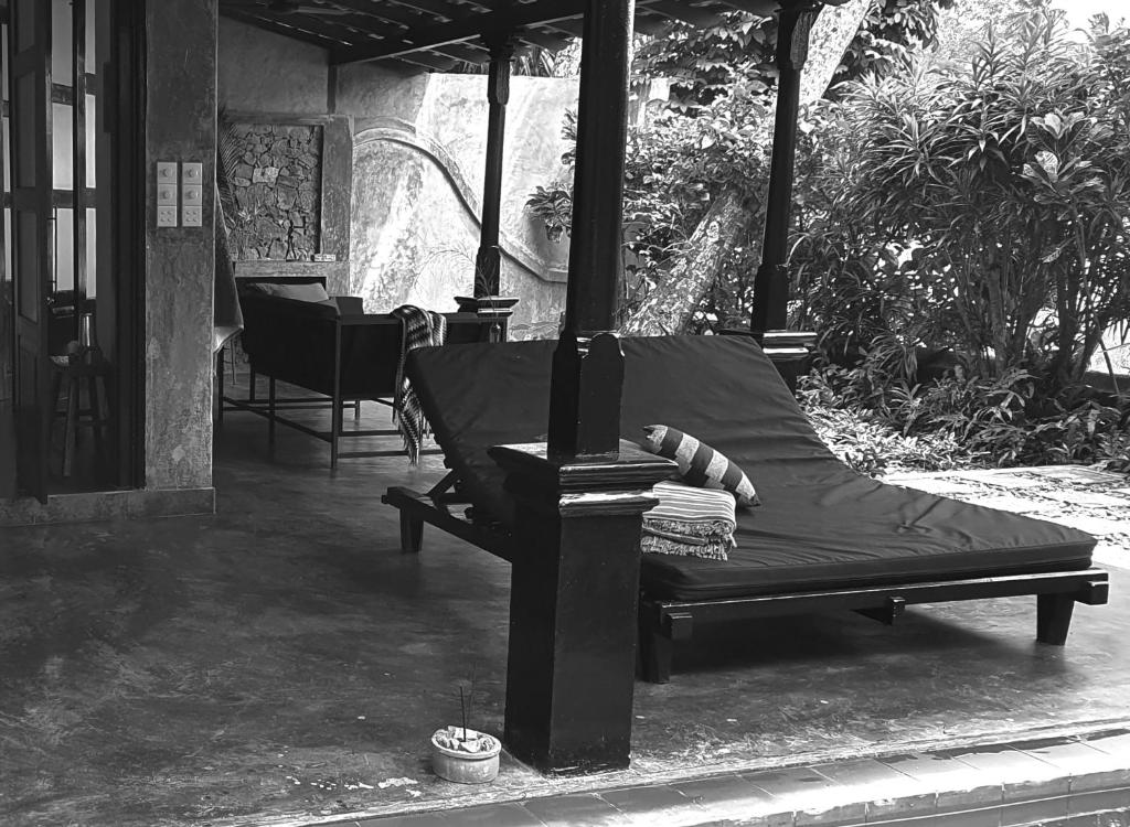 a bed sitting on the porch of a house at 9Provinces Gatehouse in Galle