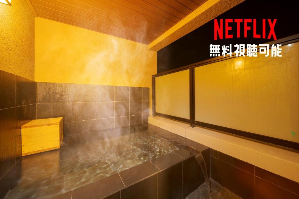 a bathroom with a yellow wall and a sign that reads netflix at Tabi no yado Hanakeshiki Ume 3rd floor - Vacation STAY 42983v in Yufuin