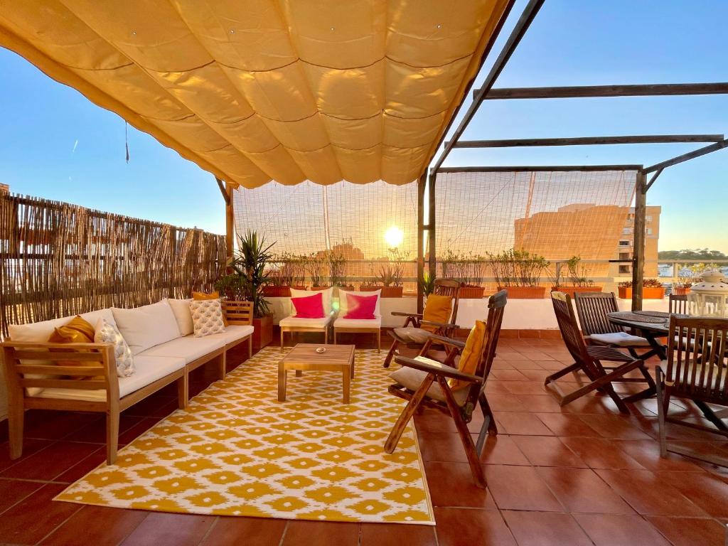 patio con divano e sedie sul tetto di WONDERFUL PENTHOUSE BY THE SEA a Lepe