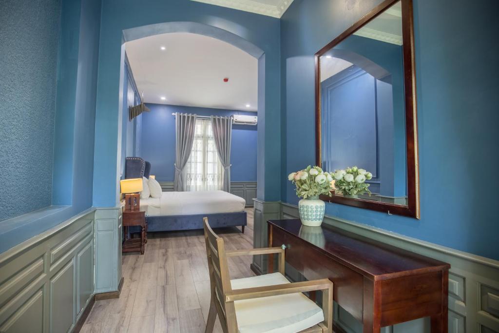 A bedroom corner with a writing desk, mirror, and seating area.