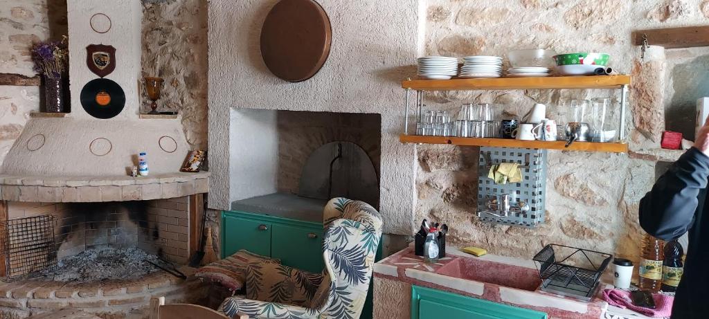 a kitchen with a fireplace and a counter with a table at Old winery in Spata